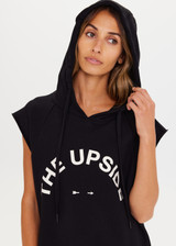 THE UPSIDE Recovery Hoodie in Black is an organic cotton sleeveless, longline hoodie with a cream horseshoe logo print at centre front and raw edges with kangaroo pocket and drawcord through hood.