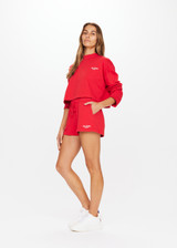 THE UPSIDE Courtsport Sabine Top in Chilli Red is a sustainable organic cotton cropped long sleeve top with ribbed mock neck, printed THE UPSIDE SPORT college logo in white and drop shoulders.