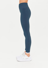 THE UPSIDE Form Seamless 25inch Midi Pant in Pool Blue is a solid knitted seamless mid-rise 7/8 length legging with a contrast white edge stripe at cuffs.