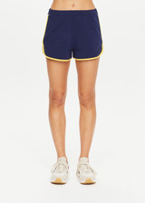 THE UPSIDE Bamford Callie Short in Navy is a sustainable organic cotton mid-rise mini 70s inspired jogger short with pockets, elasticated waist, contrast rib bind down side seam and hem and embroidered with our varsity TU patch.