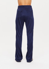 THE UPSIDE womens navy mid rise Celeste Pant made with slinky fabrication features a relaxed straight leg silhouette, elasticated waistband, drawcord, and white stripe down side seams.