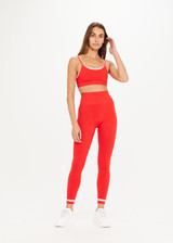 THE UPSIDE women’s red Form Seamless 25 Inch Midi Pant made with solid knit fabrication features a ⅞ leg length, white contrasting stripes on ankles and moisture wicking properties; perfect for yoga, pilates or barre.