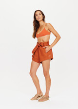 THE UPSIDE x THE BANYA orange rust short is made from heavy organic cotton and features a paper bag elastic waist, self-tie removable belt and welt pockets.