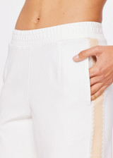 THE UPSIDE women's natural cream Petra Flare pant is made from a recycled tech fleece fabrication and features splits at front, contrast knitted tape down side seams, elasticated waist and side seam pockets.