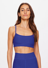 THE UPSIDE women's blue Carnaby Hutton Scoop Bra is made from a soft recycled ribbed fabrication. This scoop neck sports bra feature adjustable straps and removable bust cups and shelf bra. Designed for yoga, pilates and barre.