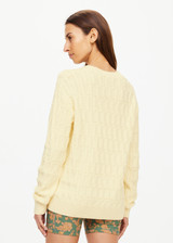 THE UPSIDE women's butter yellow Boo Cable Knit Sweater is made with organic cotton and features a patch pocket at chest and ribbed cuff, neck, and hem.