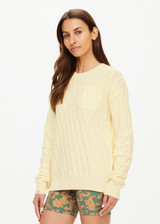 THE UPSIDE women's butter yellow Boo Cable Knit Sweater is made with organic cotton and features a patch pocket at chest and ribbed cuff, neck, and hem.