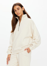 THE UPSIDE women's white organic cotton Hamilton Wren Half Zip Sweater is designed for a regular fit and features a embroidered horseshoe logo. Perfect for everyday.