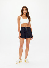 THE UPSIDE women's navy pinstripe merino Wool Cadiz Pleated Skirt features an inner short and pockets with elasticated waistband. Perfect for tennis and pickleball.