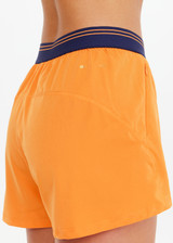 THE UPSIDE women's orange recycled fabric Elixir Lucky Run Short is designed for a relaxed fit and features an elasticated waistband and curved hem. Ideal for running.