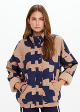THE UPSIDE women's organic cotton Mirage Carmen Quilted Jacket is an oversized fit and features a zip opening and pockets in our navy and tan geometric print. Made for lifestyle.