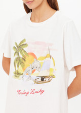 THE UPSIDE women's organic cotton creme Feeling Lucky Jodhi Tee features a classic shape and Feeling Lucky graphic printed on the front chest. Made for everyday wear.