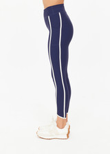 THE UPSIDE women's navy recycled peached Samara 25inch Legging is a soft & supportive fit and features side pockets and contrast cream stripes with curved hem detail. Made for pilates.
