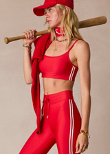 THE UPSIDE women's red eco tech Oxford Hutton Scoop Bra offers support and comfort with cream side stripes, adjustable straps, removable cups, and shelf bra. Made for high impact.