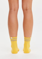 THE UPSIDE women’s yellow Curio Crew Sock with jaquard stripes in gold metallic yarn.
