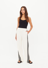 THE UPSIDE women’s cream Roma Pant is a true-to-size fit and features an elasticated waistband with drawcord, pockets and black and cream contrast stripes down sides. Perfect for everyday.