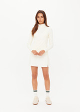THE UPSIDE women's cream Courtship Dova Run Top is a form fitting long-sleeve and features a quarter zip opening with mock neck, thumb holes and invisible zip pockets. Made for running.
