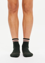 THE UPSIDE women's green Tamara Grip Sock features a soft terry sole, mid ankle height and pink stripe details. Made for yoga & pilates.