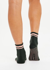 THE UPSIDE women's green Tamara Grip Sock features a soft terry sole, mid ankle height and pink stripe details. Made for yoga & pilates.