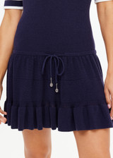 THE UPSIDE women's navy tennis Plume Knit Collared Dress fits true-to-size and features a drop waist with gathered skirt and a drawcord with tennis charms.
