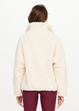 THE UPSIDE women's natural recycled polyester Harlow Fleece Pullover has a relaxed fit with a striped rib collar, contrast maroon stripes, and zip pockets. Made for lifestyle