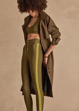 THE UPSIDE women's olive eco tech Oxford 25 Inch Midi Pant is designed for a supportive and comfortable fit and features mid-rise with lime contrast side binds. Made for high impact.