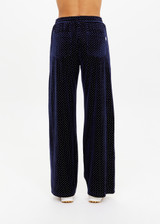 THE UPSIDE women's navy polka dot Spellbound Roma Pant is true to size and features metallic silver spots on velvet fabrication and side seam pockets. Made for lifestyle.
