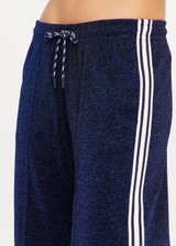THE UPSIDE women's navy Galaxia Loretta Pant is designed for a mid to low rise fit and features elasticated waistband, drawcord with side seam pockets and knitted tape down sides. Made for lifestyle.