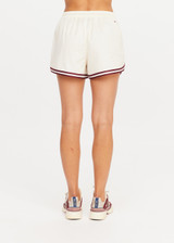 THE UPSIDE women's cream Klio Short is designed for a mid-rise, relaxed fit and features a soft elasticated waistband with drawcord and contrast binds in maroon along curved hem. Made for everyday.