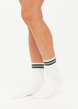 THE UPSIDE women's cream Courtship Crew Sock features green jacquard stripes and cream arrow logo at edge.