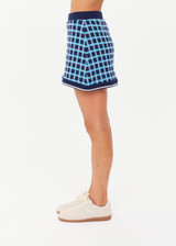THE UPSIDE women's navy and blue plaid cotton Clubhouse Reece Mini Skirt is designed as a faux wrap skirt featuring a soft elastic waistband and a curved hemline. Made for tennis, golf & pickleball.