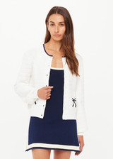 THE UPSIDE women's cream Jolie Isabeli Knit Cardigan is a regular fit with a blouson sleeve crafted from a pointelle knit and features navy embroidered bows. Made for tennis, golf & pickleball.