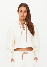 THE UPSIDE women's cream organic cotton terry Arkana Priah Hoodie is designed for a relaxed fit with dropped shoulders and features a lace up front. Made for lifestyle.