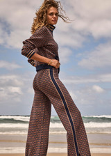THE UPSIDE women's brown organic cotton Lumiere Juniper Knit Pant is a straight leg pant with a geometric star pattern, a soft elasticated waistband with drawcord and side seam pockets. Made for lifestyle.