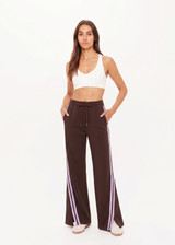 THE UPSIDE women's brown Roma Pant features a high rise with an elasticated waistband, pockets, and a side stripe with lilac mesh. Made from recycled double faced single jersey fabrication. Made for lifestyle.