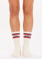 THE UPSIDE women's cream Two Hearts Crew Sock features jacquard stripes in red and burgundy and two black hearts on the ankle. Made for lifestyle.