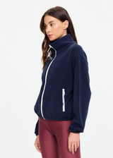 THE UPSIDE women’s navy recyled Sol Fleece Jacket offers a relaxed fit and features a zip through front, front zip pockets, elasticated waist and cuffs and contrast paracord zip pullers. Made for lifestyle.