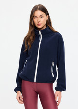 THE UPSIDE women’s navy recyled Sol Fleece Jacket offers a relaxed fit and features a zip through front, front zip pockets, elasticated waist and cuffs and contrast paracord zip pullers. Made for lifestyle.