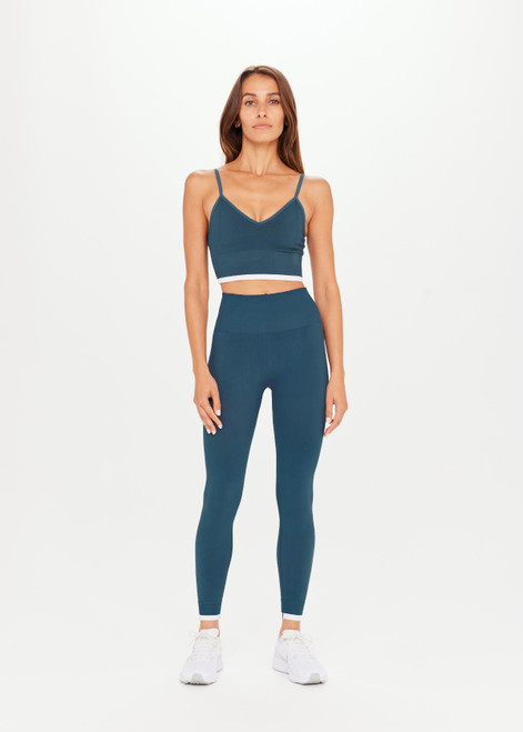 THE UPSIDE Form Seamless 25inch Midi Pant in Pool Blue is a solid knitted seamless mid-rise 7/8 length legging with a contrast white edge stripe at cuffs.