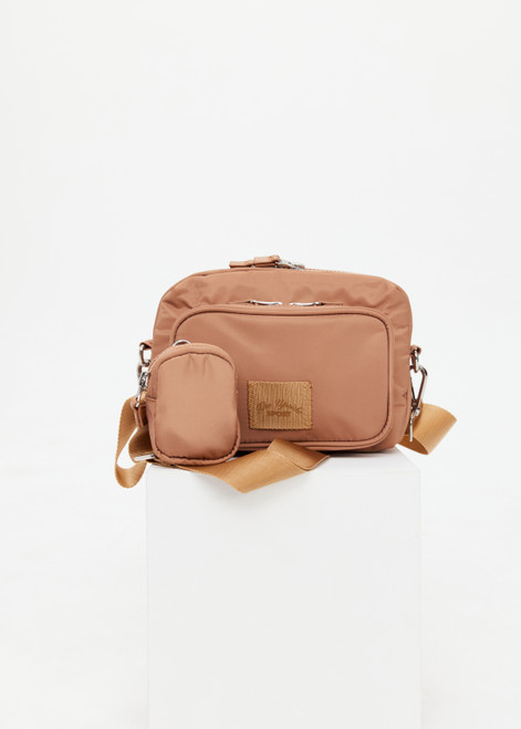 THE UPSIDE women's tan recycled fabric Odyssey Crossbody Bag features an adjustable and removable strap, multiple zippered pockets and silver hardware.