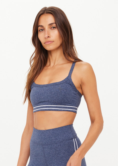 THE UPSIDE women's blue Bowery Baxter Tbar Sports Bra features a scooped neckline with ultraflex recycled fabrication, removeable bust cups and cream embroidered stripes at underbust. Made for yoga & pilates.
