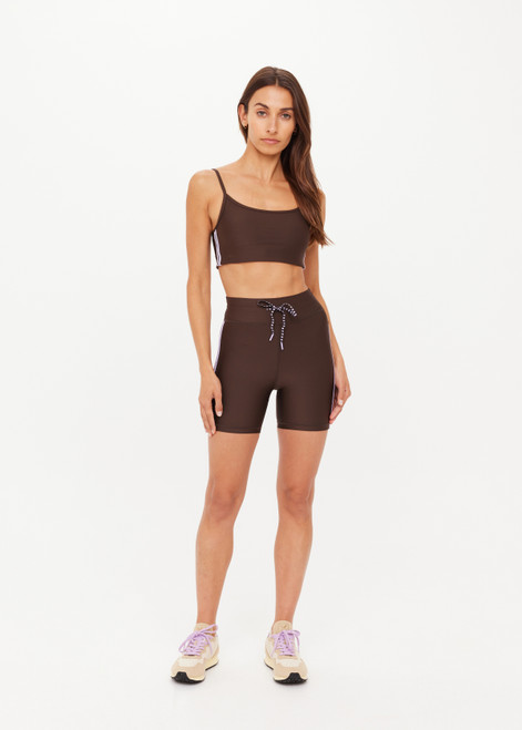 THE UPSIDE women's brown eco tech Oxford 5Inch Spin Short offers a mid rise with lilac coloured binds down side seams and an elastic drawcord through waist. Made for high impact.