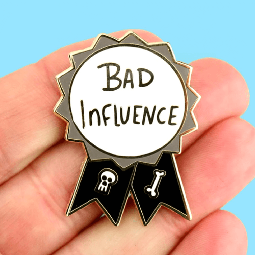 The Jubly-Umph - Bad Influence Award Lapel Pin is a bold and whimsical accessory that celebrates the spirit of nonconformity and individuality.