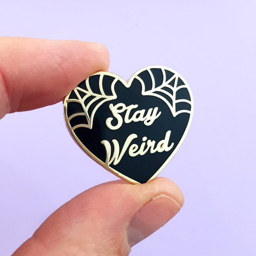 The Jubly-Umph - Stay Weird Black Lapel Pin is an ode to everyone who never let societal pressures change their quirky essence.