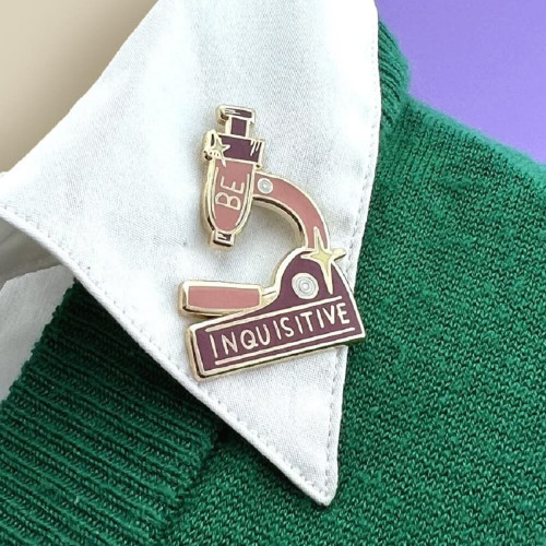 The Jubly-Umph - Be Inquisitive Lapel Pin is a striking accessory representing the pursuit of knowledge, curiosity, and the unending quest for understanding.