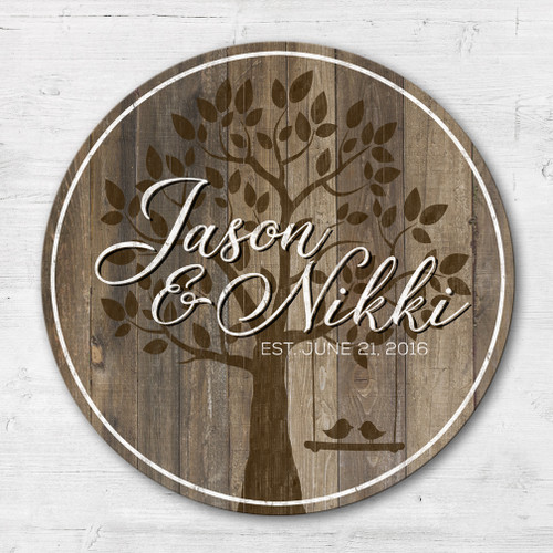 Personalized round wood family name sign with custom last name and established date, rustic farmhouse wedding gift displayed on a neutral wall.
