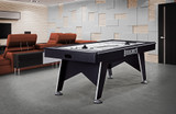 Brunswick Billiards Brunswick Windchill 7' Air Hockey Table - Modern Indoor Game Table, sleek black air hockey table set up in a contemporary game room with comfortable orange seating.