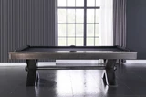 Plank & Hide Co VOX Steel Slate Pool Table, modern sleek pool table with black legs and steel slate playing surface in a contemporary room with large window.