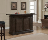 American Heritage Billiards Valore Home Bar, a dark wood home bar with paneled doors, in a living room with beige walls and framed artwork.