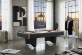 C.L. Bailey Addison Slate Pool Table in Black, modern pool table in a stylish urban living room with large windows, city view, and contemporary decor.